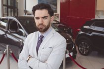 Portrait of confident salesman standing with arms crossed — Stock Photo