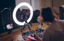 Female video blogger applying make up on face at home — Stock Photo