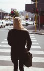 Visão traseira da mulher hijab andando na travessia da zebra — Fotografia de Stock