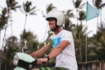 Uomo felice cavalcando scooter in strada città — Foto stock