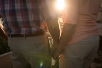 Mid section of a romantic senior couple holding hands — Stock Photo