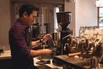 Male waiter preparing coffee in coffee shop — Stock Photo