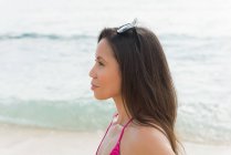 Donna in piedi in spiaggia in una giornata di sole — Foto stock