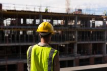 Rear view of female architect standing at construction site — Stock Photo