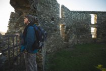 Junge männliche Wanderer stehen in alter Ruine auf dem Land — Stockfoto