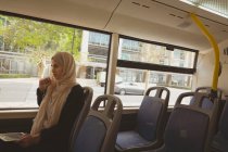 Красива хіджаб жінка розмовляє на цифровому планшеті під час подорожі в автобусі — стокове фото
