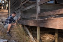 Mann hämmert Holzplanke mit Hammer an einem sonnigen Tag — Stockfoto