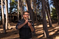 Uomo pronto a scattare foto della natura con macchina fotografica nella foresta — Foto stock