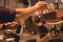 Sección media del camarero preparando café en la cafetería - foto de stock
