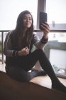 Young female dancer taking selfie with mobile phone in dance studio — Stock Photo