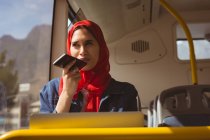 Beautiful hijab woman talking on mobile phone in the bus — Stock Photo