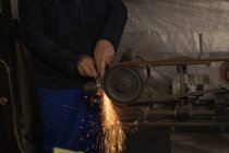 Lavoratore sagomatura metallo sulla macchina in hangar aereo — Foto stock