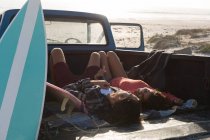 Couple relaxing in a pickup truck at beach on a sunny day — Stock Photo