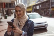 Hermosa mujer hijab urbano utilizando el teléfono móvil - foto de stock