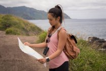 Beautiful woman looking at map in countryside — Stock Photo