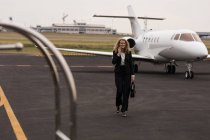 Bella donna d'affari che parla sul cellulare mentre cammina al terminale — Foto stock