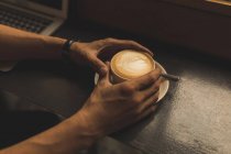 Gros plan de l'homme d'affaires tenant une tasse de café dans le café — Photo de stock