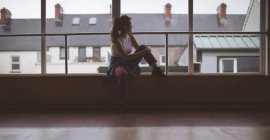 Ragionevole ballerina che guarda attraverso la finestra in studio di danza — Foto stock