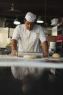 Reifer Bäcker mit Nudelholz in Bäckerei — Stockfoto