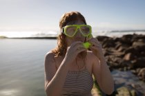 Mulher usando máscara de snorkel perto da costa do mar em um dia ensolarado — Fotografia de Stock