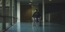 Gehbehinderter Rollstuhlfahrer bewegt sich in Durchgang an Turnhalle — Stockfoto