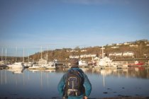 Visão traseira do caminhante masculino em pé com mochila no porto — Fotografia de Stock