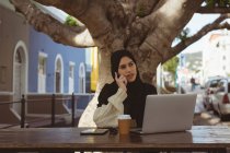 Beautiful urban hijab woman talking on mobile phone at cafe — Stock Photo
