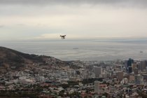 Беспилотник летит в воздухе над городским пейзажем — стоковое фото