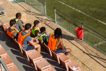 Vista ad alto angolo dei giocatori di calcio che si rilassano sulla panchina — Foto stock