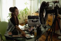 Schöne weibliche Video-Bloggerin mit Make-up-Accessoires zu Hause — Stockfoto