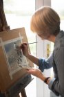 Female artist painting picture on canvas at home — Stock Photo