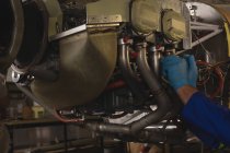 Close-up do engenheiro de reparação de motores de aeronaves no hangar — Fotografia de Stock