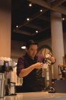 Smart waiter preparing coffee in coffee shop — Stock Photo