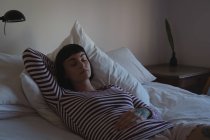 Junge Frau entspannt sich im Schlafzimmer zu Hause — Stockfoto