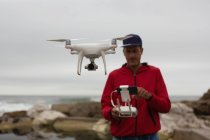 Человек, управляющий летающим дроном в сельской местности — стоковое фото