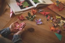 Женщина, показывающая оригами дома — стоковое фото