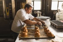 Panettiere maschile che prepara croissant rotondi in panetteria — Foto stock
