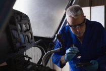 Engineer examining cockpit in aerospace hanger — Stock Photo