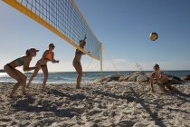 Jugadoras de voleibol jugando voleibol en la playa - foto de stock