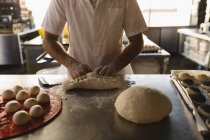 Männerbäcker bereitet Teig in Bäckerei zu — Stockfoto