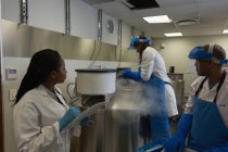 Wissenschaftler führen Aufzeichnungen medizinischer Proben auf Klemmbrett im Labor — Stockfoto