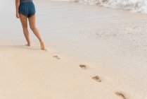 Низкая часть женщины, гуляющей по пляжу в солнечный день — стоковое фото