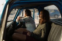 Couple relaxing in a pickup truck at beach on a sunny day — Stock Photo