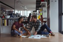 Architekten interagieren im Büro auf dem Fußboden miteinander — Stockfoto
