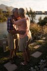 Beau couple de personnes âgées s'embrassant près de la rivière — Photo de stock