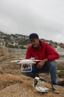 Mann betätigt fliegende Drohne auf einem Felsen — Stockfoto
