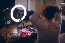 Mujer video blogger peinando su cabello en casa - foto de stock