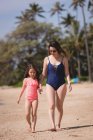 Mother and daughter walking together in the beach on a sunny day — Stock Photo