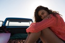 Portrait of woman relaxing in a pickup truck at beach — Stock Photo