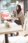 Удумлива жінка з кавою в кав'ярні — стокове фото